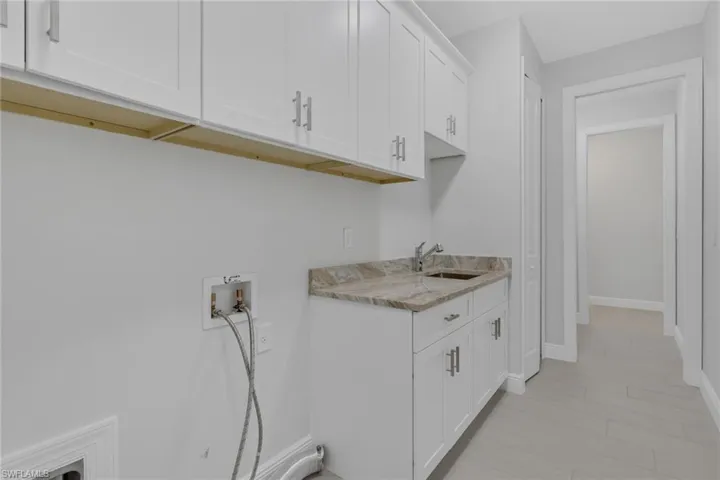 full sized laundry with utility sink and extra storage