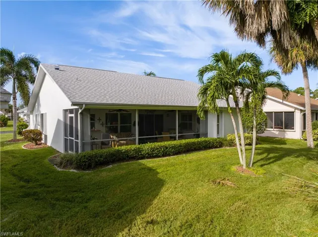 Back of property featuring a lawn and a sunroom