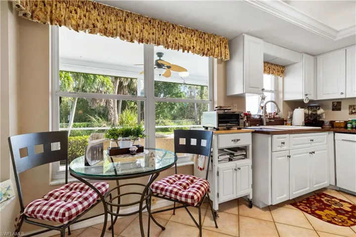 Kitchen featuring a wealth of natural light, white dishwasher, and white cabinets