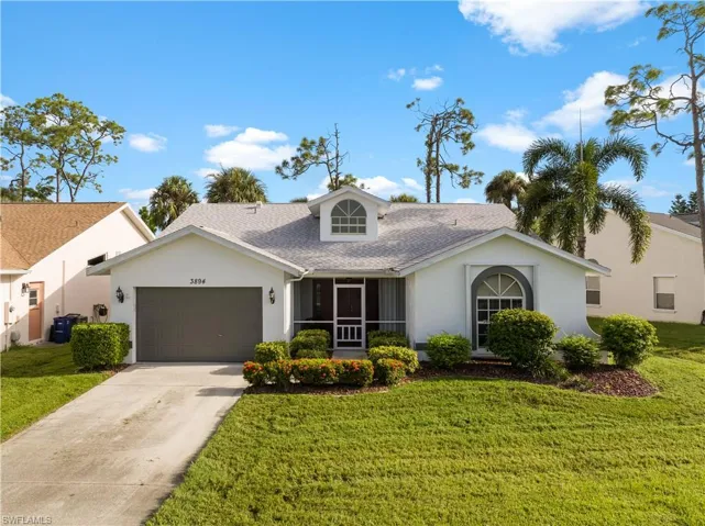 View of front of house featuring a garage, central AC unit, and a front yard