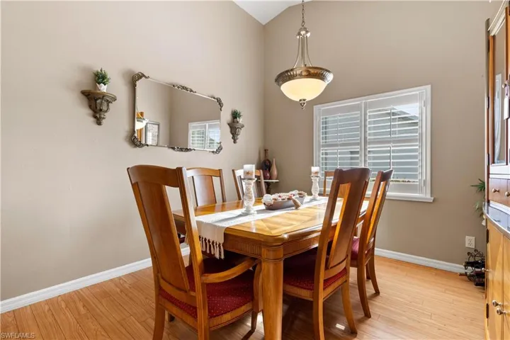 Dining room with light hardwood / wood-style flooring and vaulted ceiling