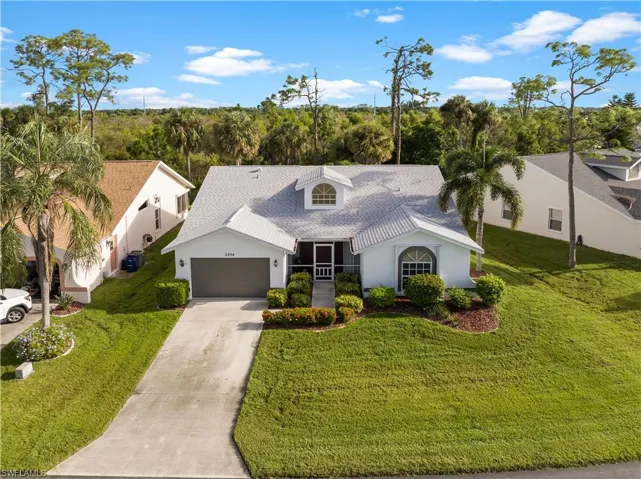View of front of home with a front lawn, a garage, and central AC unit