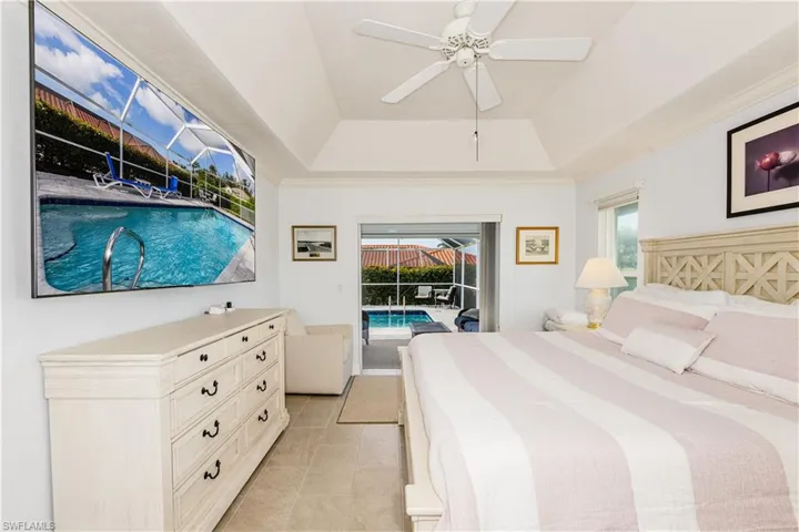 Bedroom with a raised ceiling, crown molding, access to exterior, and ceiling fan