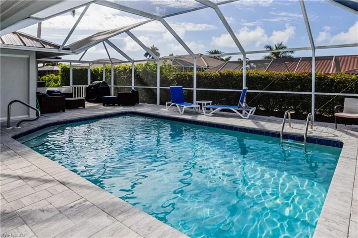 View of pool featuring area for grilling, an outdoor living space, a lanai, and a patio area