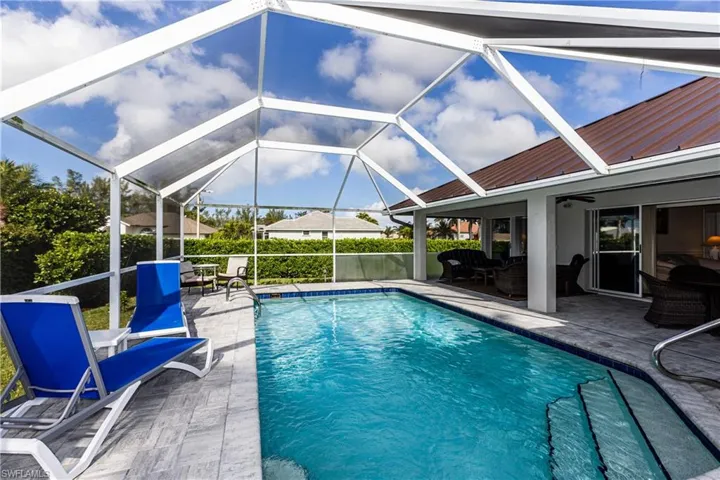 View of pool featuring an outdoor living space, a patio, ceiling fan, and glass enclosure