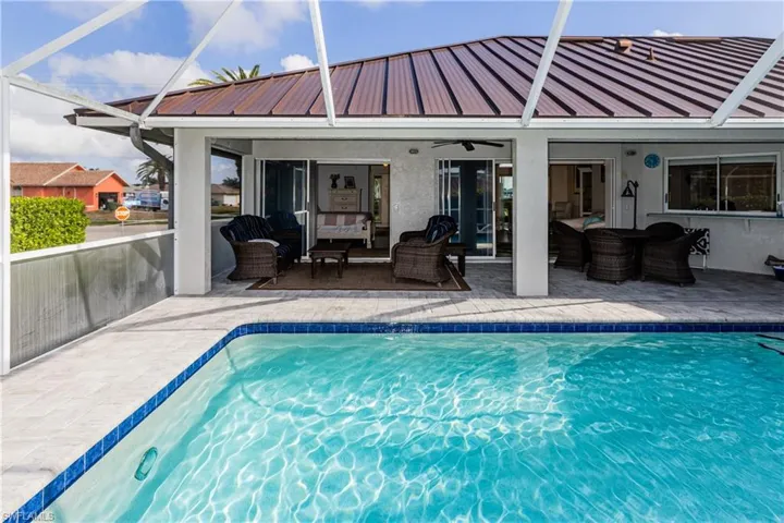 View of swimming pool featuring ceiling fan, a patio, outdoor lounge area, and glass enclosure