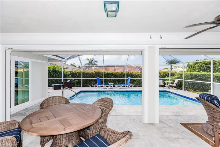 View of pool featuring a lanai, ceiling fan, and a patio area