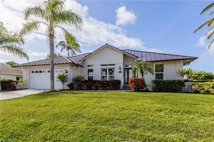 Ranch-style home featuring a garage and a front yard