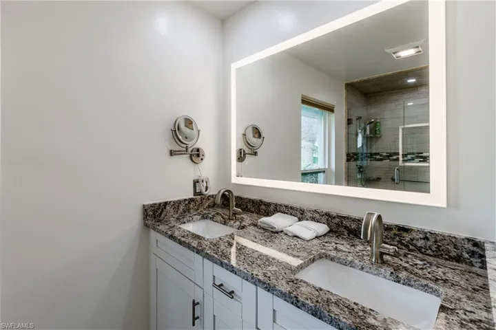 Bathroom featuring vanity and a shower with door