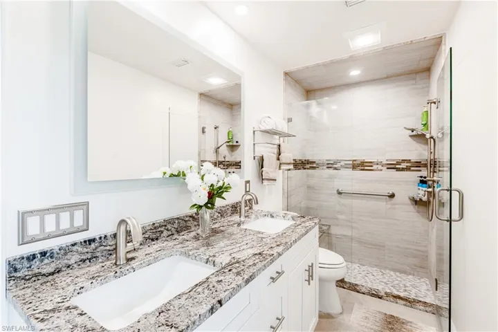 Bathroom with an enclosed shower, vanity, and toilet