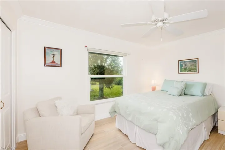 Bedroom with crown molding, ceiling fan, and light wood-type flooring