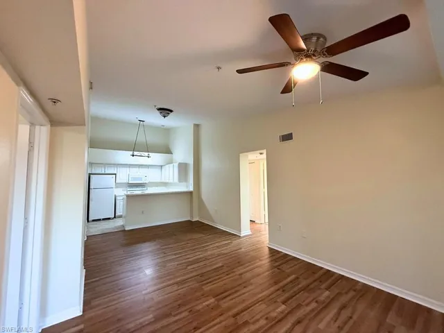 Unfurnished living room with dark wood finished floors and a ceiling fan