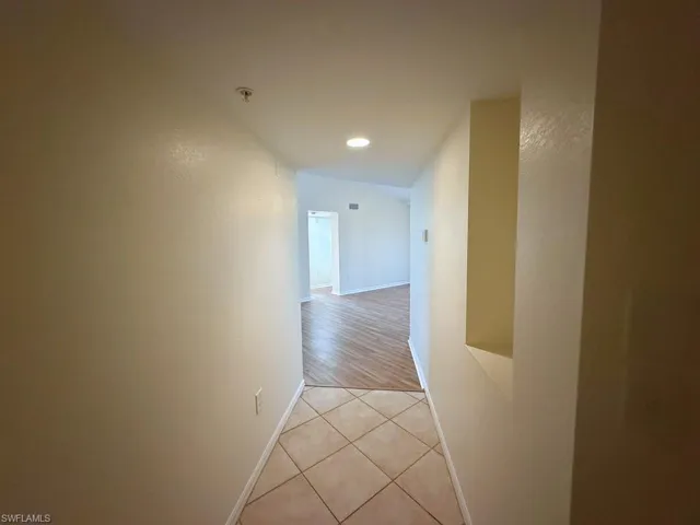 Corridor with light tile patterned floors, recessed lighting, and vaulted ceiling