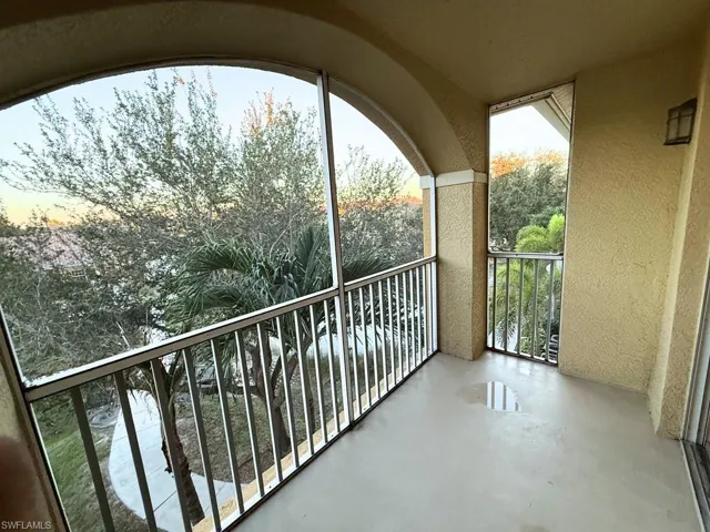 Balcony at dusk featuring a sunroom