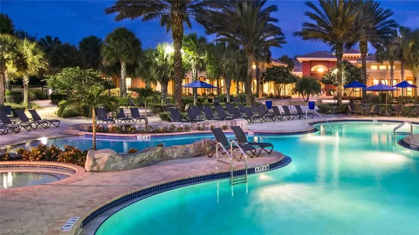 Pool at night with a community pool and a patio area