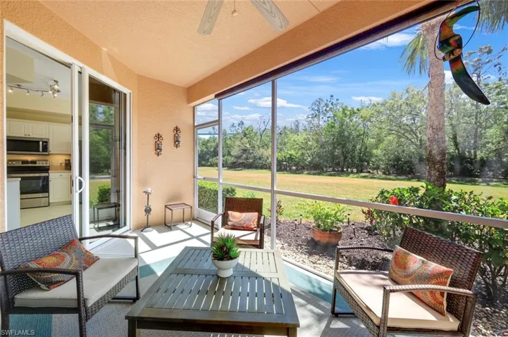Sunroom featuring ceiling fan, outdoor lounge area, and view of wooded area
