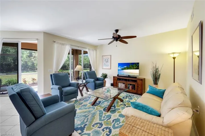 Living room featuring tile patterned floors and ceiling fan