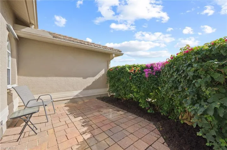 Paver patio out front surrounded by beautiful bouganvillea hedge