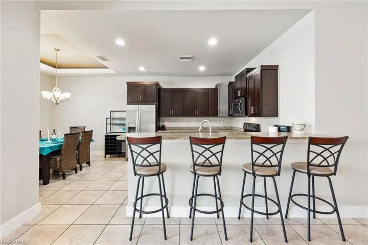 Kitchen featuring dark wood cabinetry, light-toned countertops, and stainless steel appliances