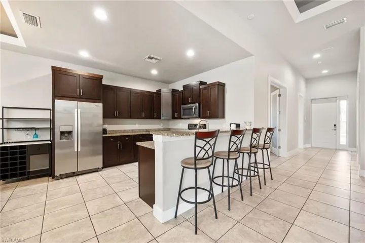 Kitchen featuring dark wood cabinetry, stainless steel appliances, and granite countertops