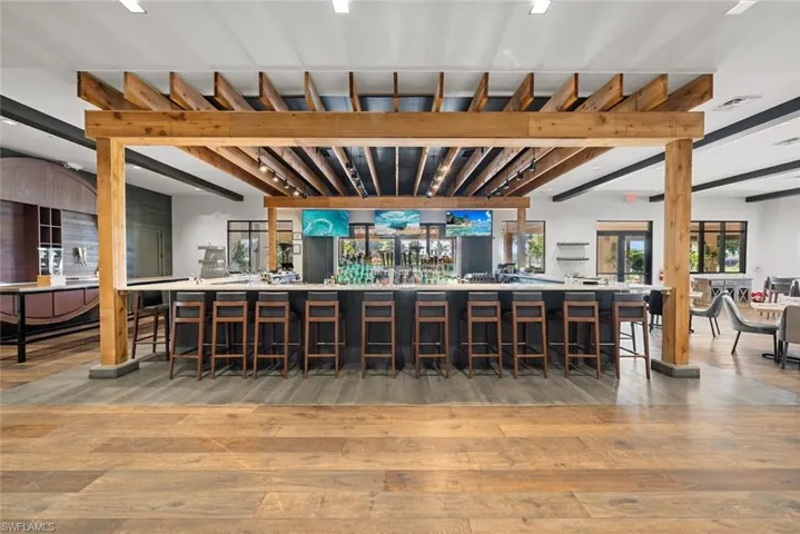 Bar featuring beam ceiling and wood-type flooring