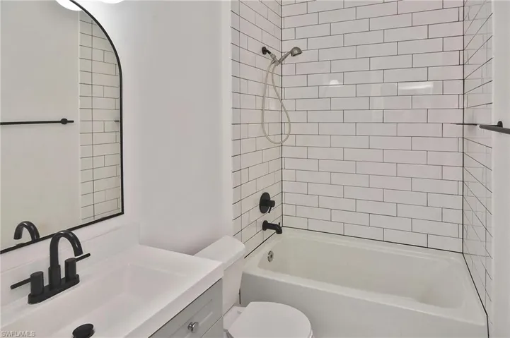 The newly updated Guest Bath is beautifully appointed with tub/shower combination, subway tile, mirror, and contemporary sink vanity
