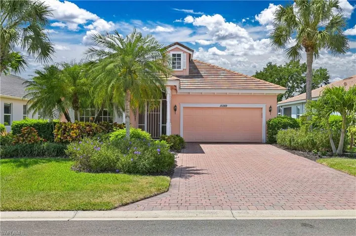 Single-story home featuring a coral exterior, red tile roof, and a dormer window