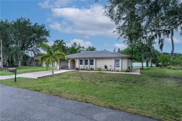Single story home featuring a garage and a front yard