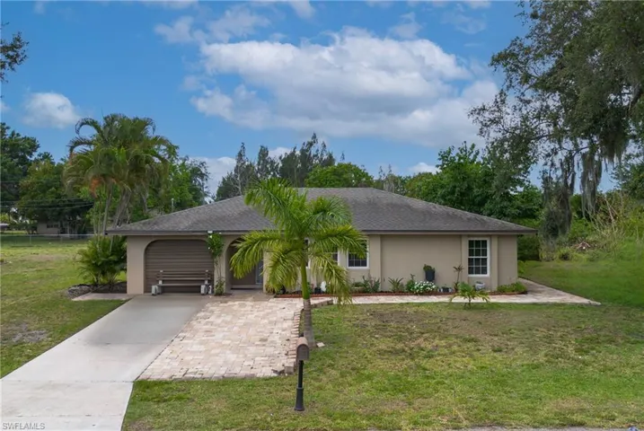 Ranch-style home featuring a front lawn