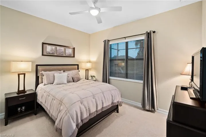 Carpeted bedroom featuring ceiling fan