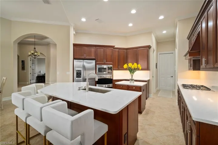 Kitchen with a breakfast bar area, light tile patterned floors, a kitchen island with sink, appliances with stainless steel finishes, and sink