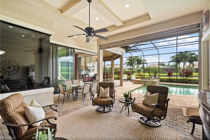 View of large covered outdoor seating area featuring grilling area, ceiling fan, and a lanai