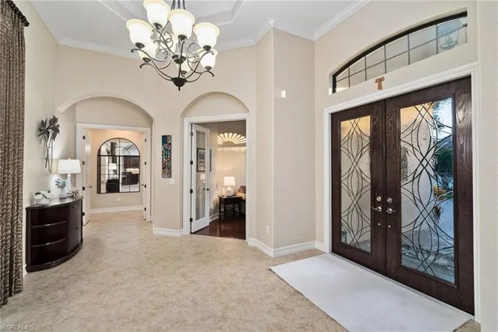 Entryway featuring ornamental molding, french doors, and a chandelier