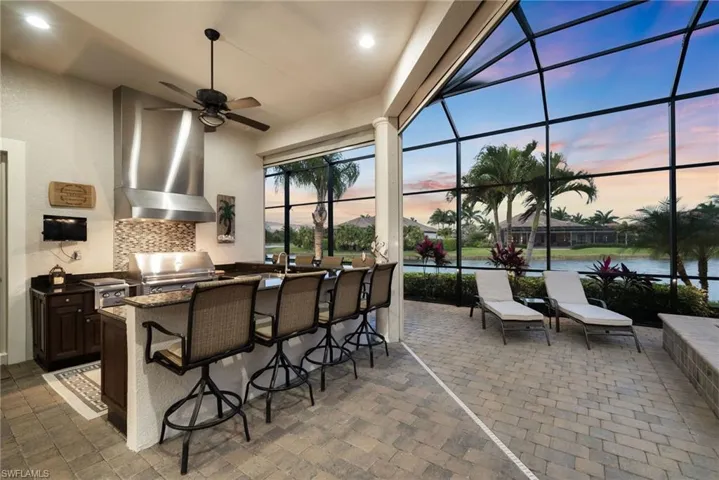 Gorgeous outdoor kitchen featuring ceiling fan