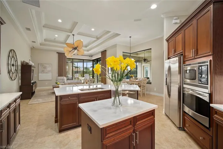 Kitchen with sink, a center island, coffered ceiling, and stainless steel appliances