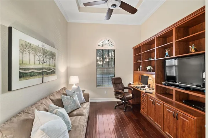 Home office with ceiling fan, crown molding, and dark hardwood / wood-style flooring