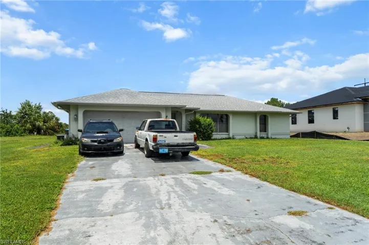 Single story home featuring a garage, a front yard, concrete driveway, and a shingled roof