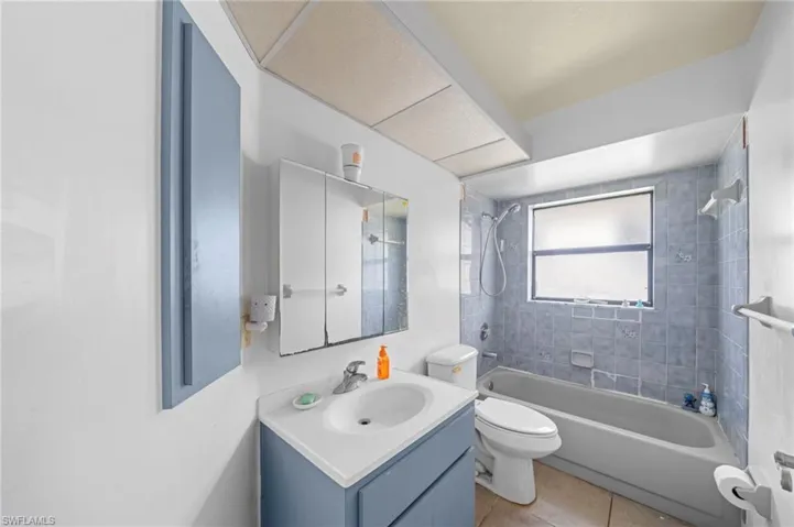 Full bath featuring vanity, shower / tub combination, and tile patterned floors