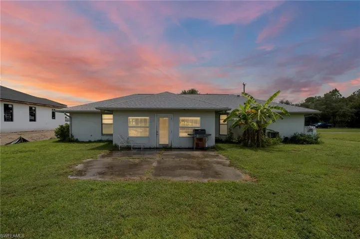 Back of property with a patio, stucco siding, and a yard