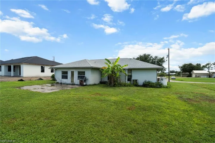 Back of property with a patio, stucco siding, and a lawn