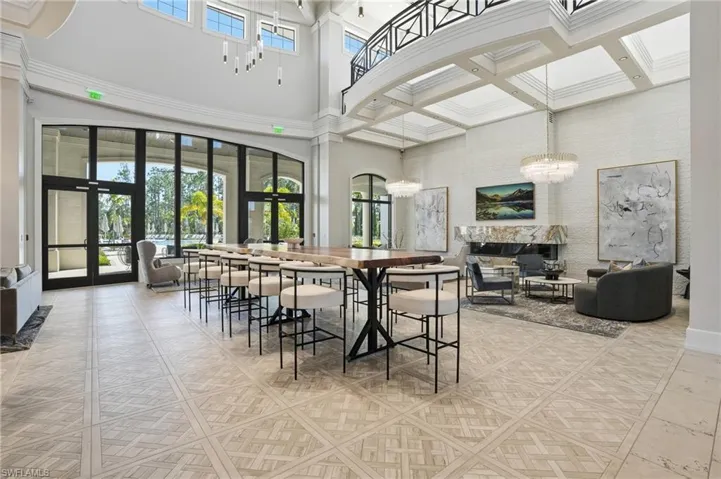 Dining room with french doors, a glass covered fireplace, a chandelier, and a high ceiling
