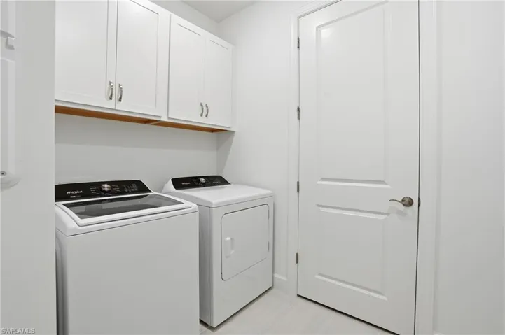 Laundry area featuring washing machine and dryer and cabinet space
