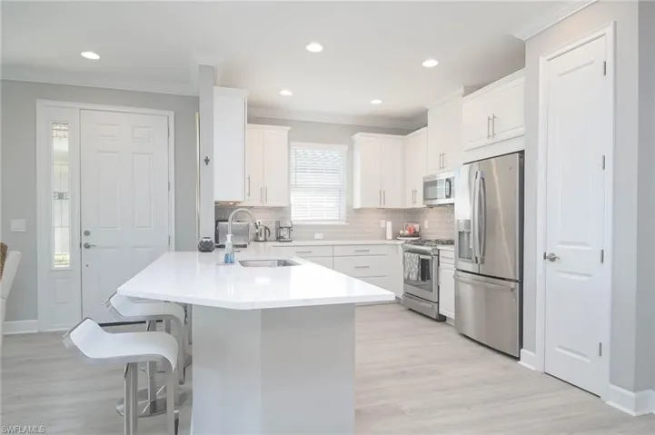 Kitchen with tile backsplash, view of Foyer