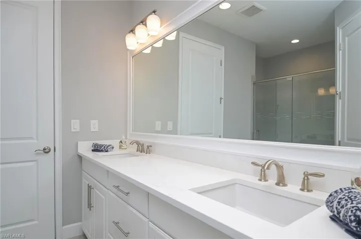 Bathroom with dual vanities, walk-in shower and large upgrade walk-in closet
