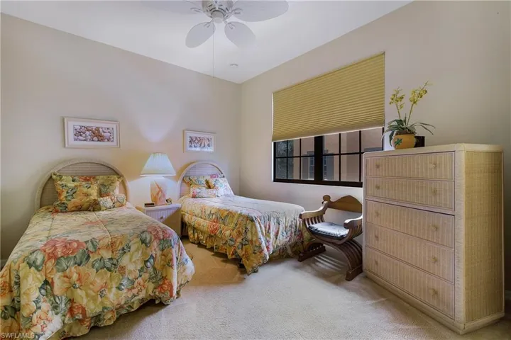 Carpeted bedroom featuring ceiling fan