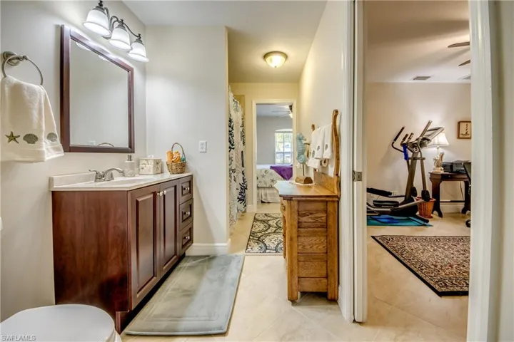 Bathroom featuring ceiling fan, vanity, and tile patterned flooring