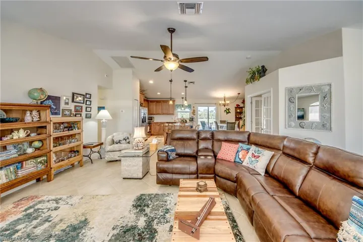 living room featuring ceiling fan and lofted ceiling