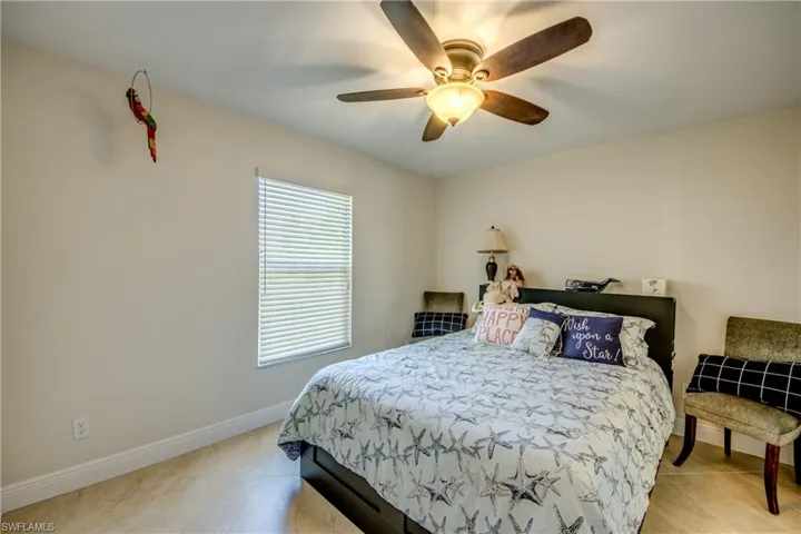 Bedroom with light tile patterned flooring and ceiling fan