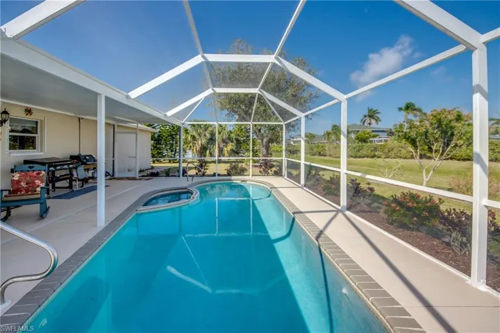 View of pool featuring glass enclosure and a patio area