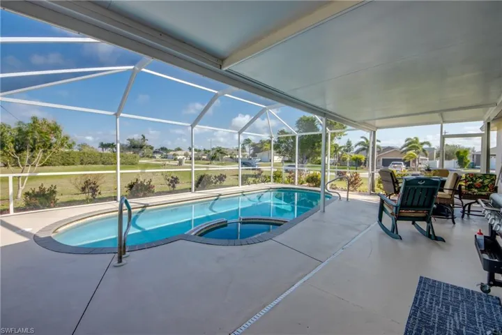 View of pool featuring an in ground hot tub, a patio, and glass enclosure